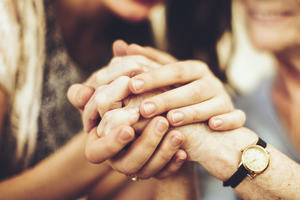 Image of young and old person holding hands
