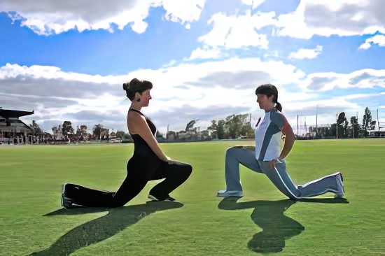 two women stretching on a grassy field