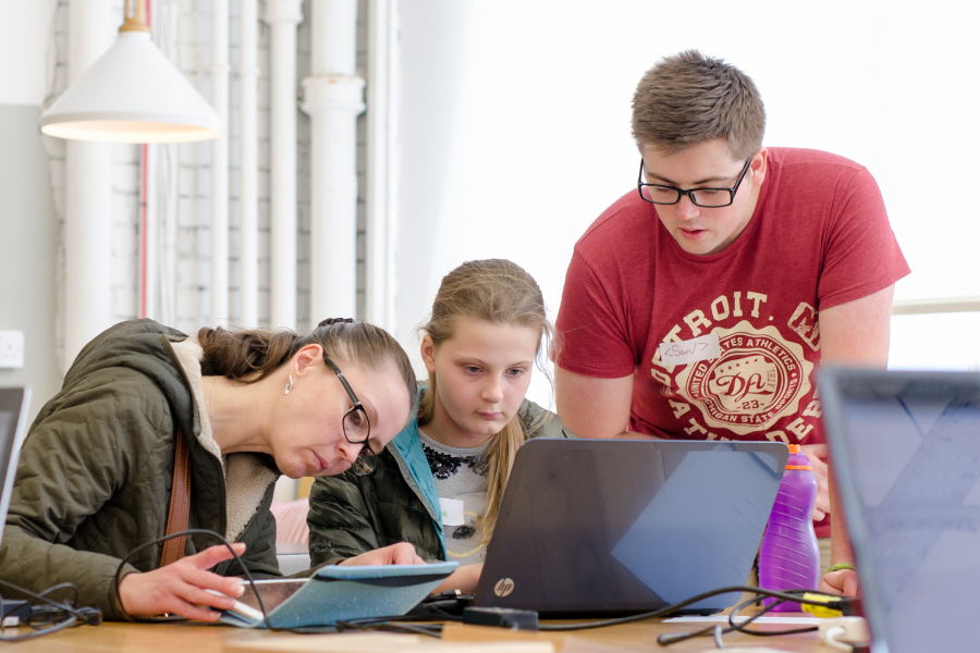 A woman, girl, and boy at a laptop