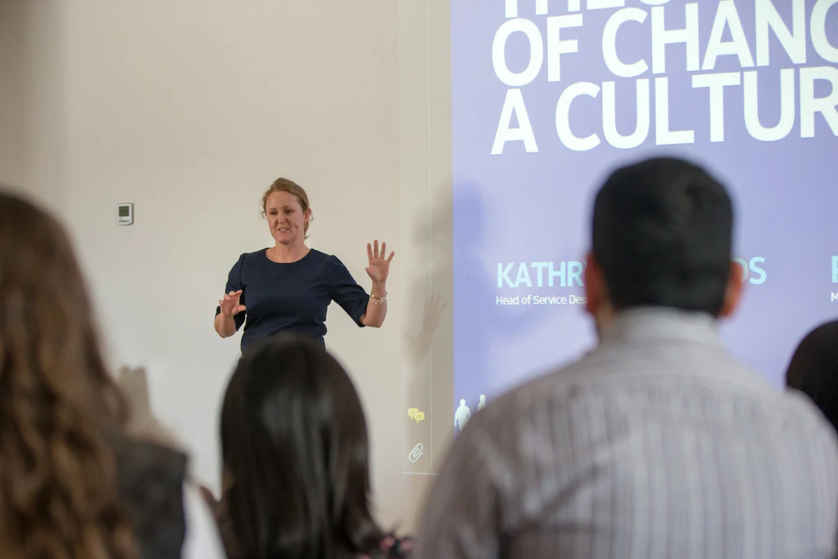 Female standing in front of screen with presentation