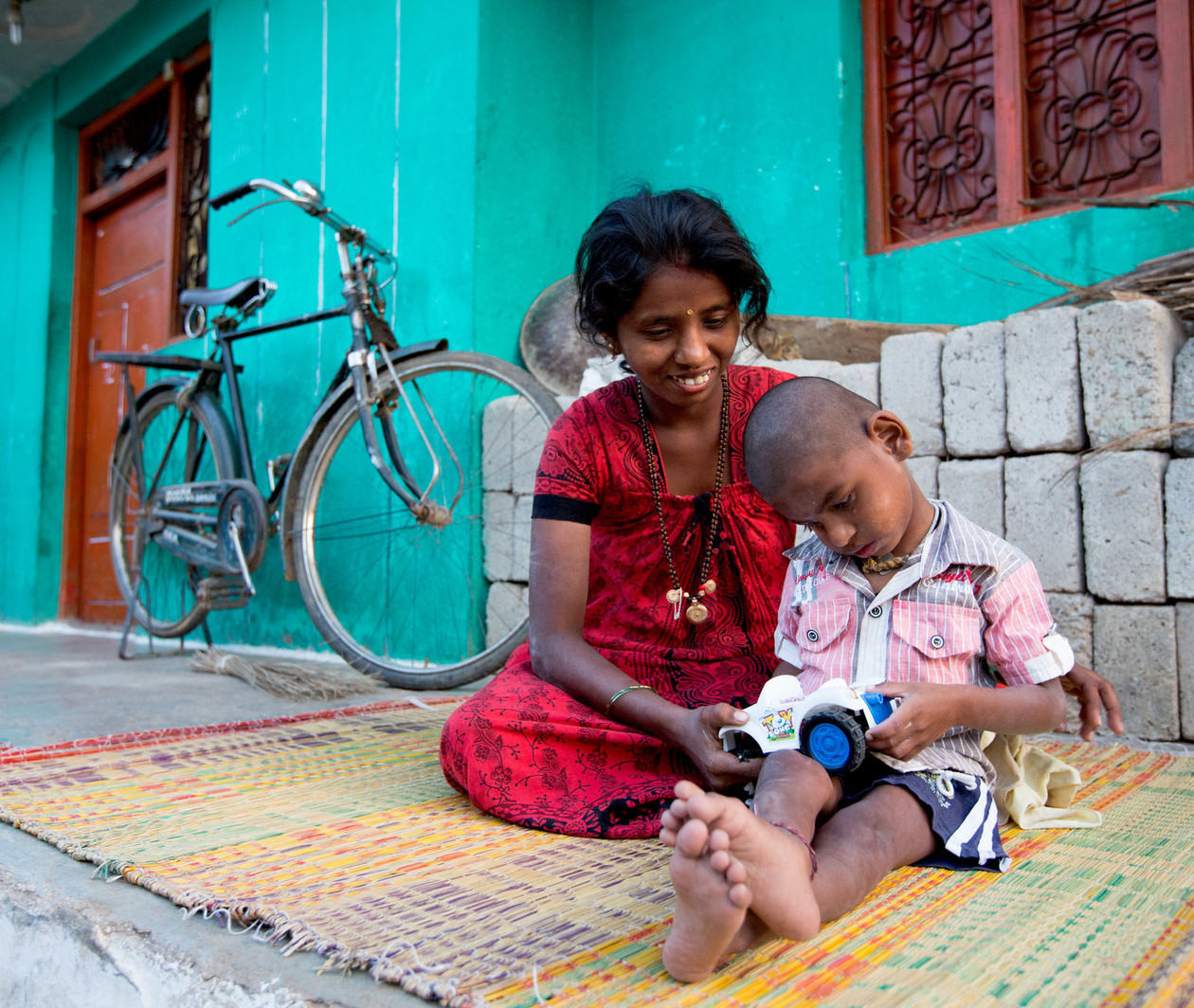 A mother plays with her son in India