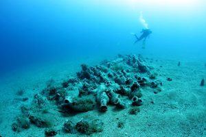 A diver exploring some amphora from a shipwreck