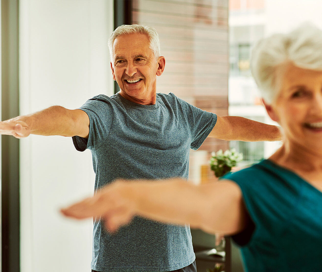 A man and women in their sixties doing exercises at home