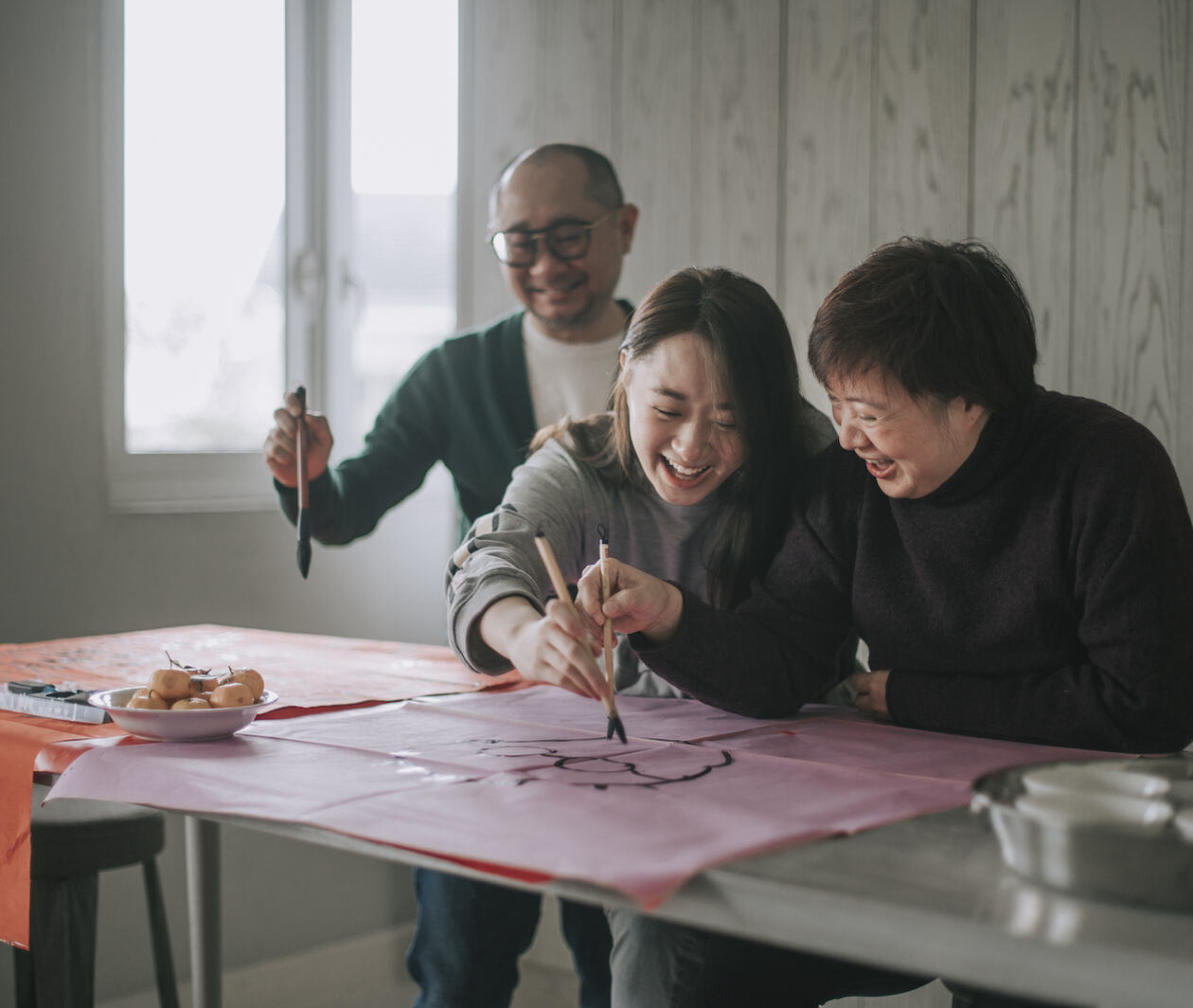 Chinese family having fun while painting at a table