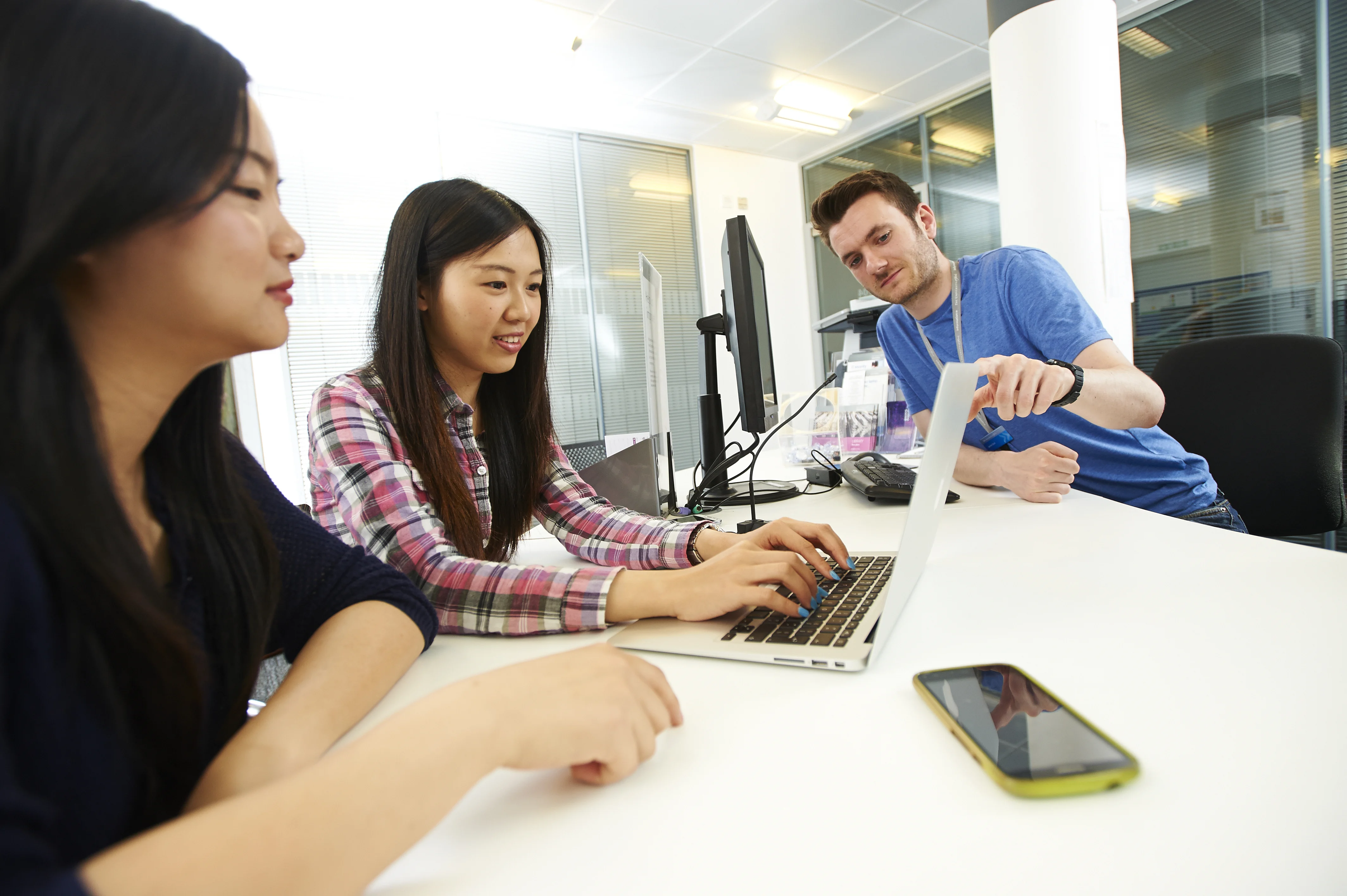 Tutor helping students on a computer