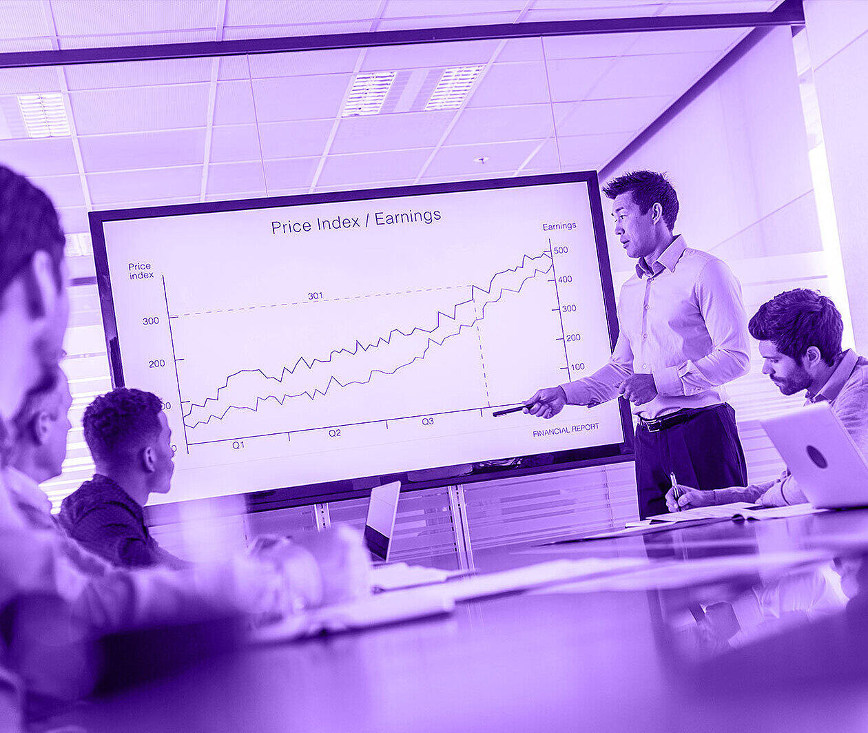 A group of colleagues around a white board with a large graph on display.