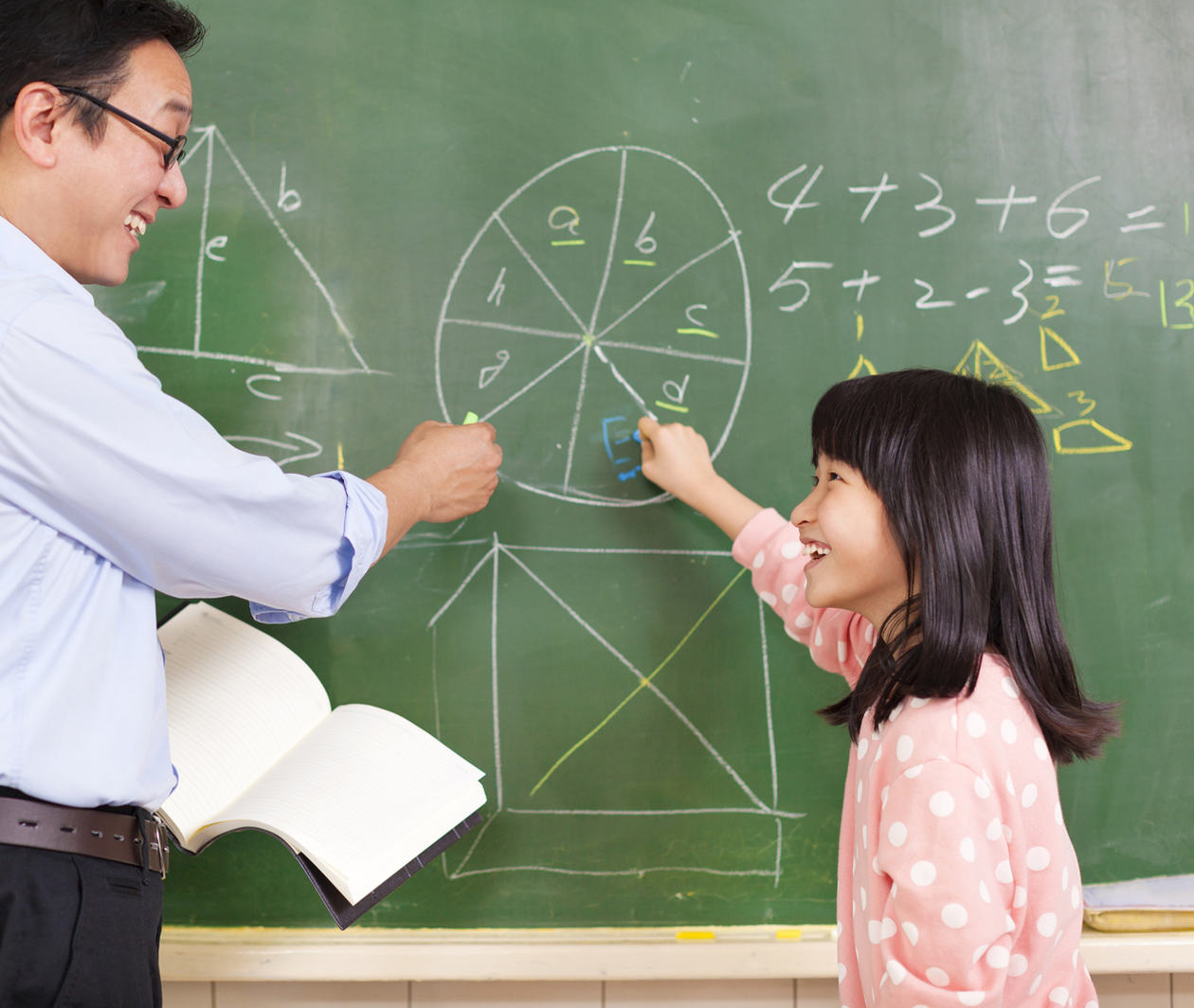 A teacher and child at a blackboard