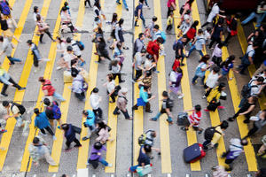 Many people crossing a road in a busy city