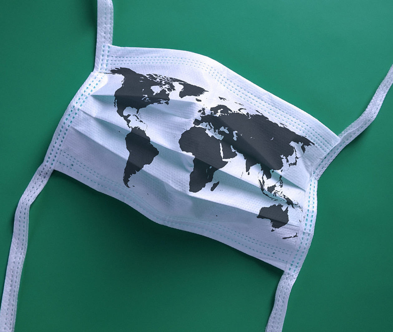 a white mask with an outline of the world across it on a green background