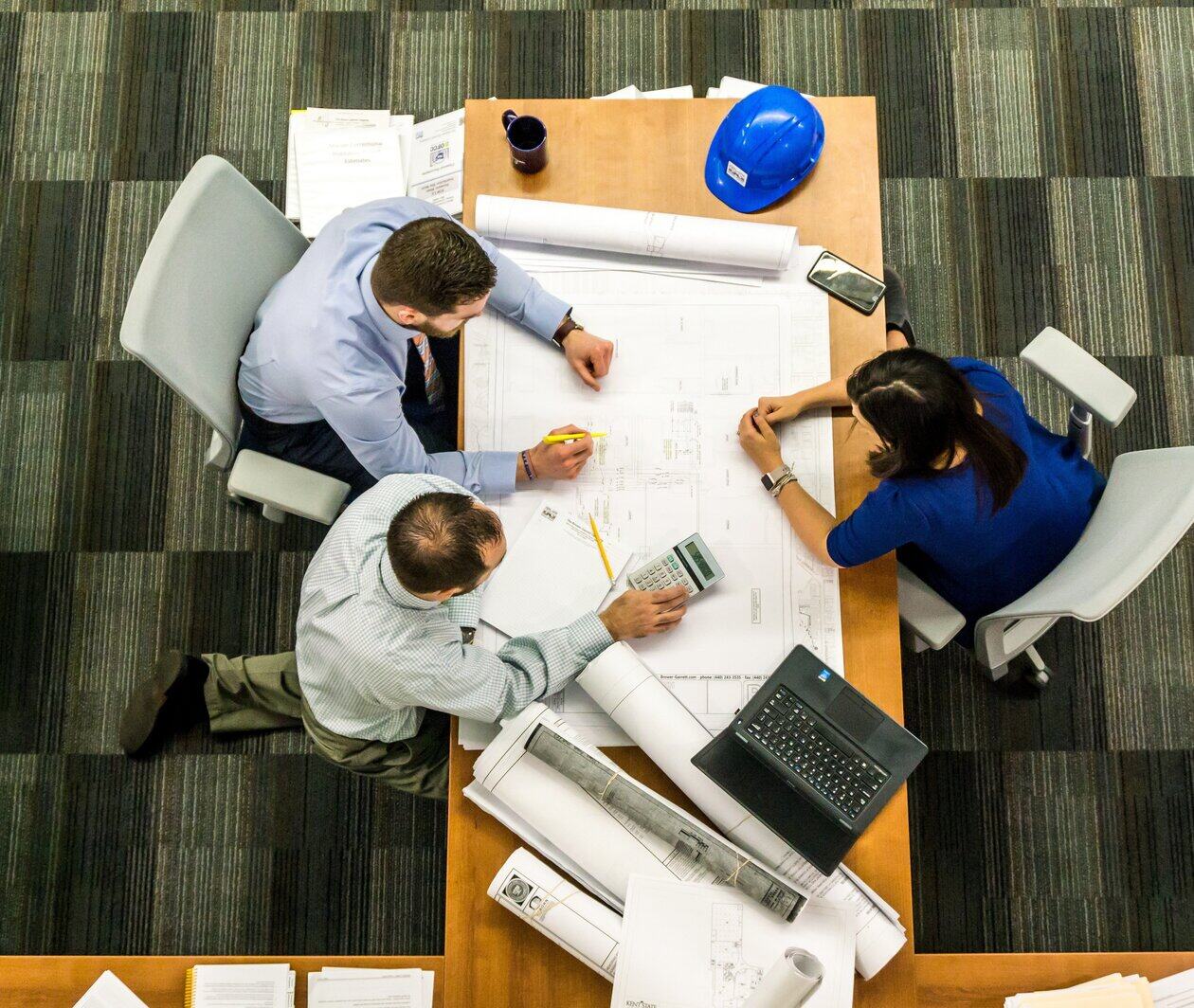 Overhead view of 3 people working together on a desk