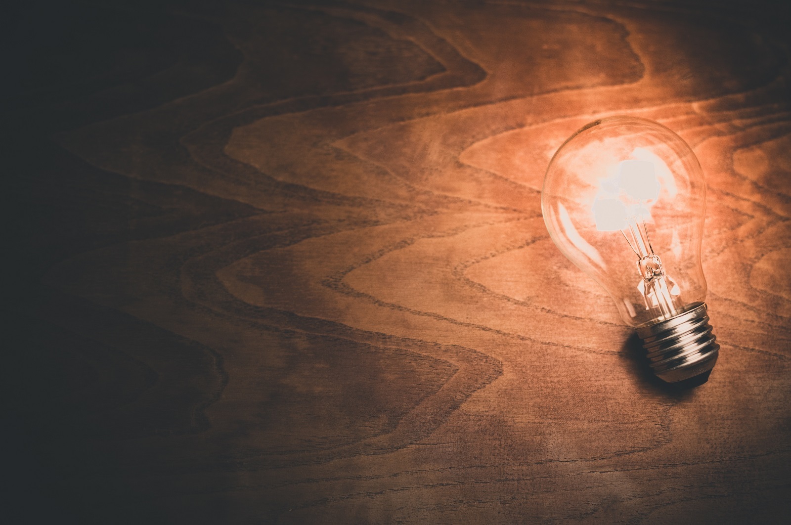 A light bulb on wooden background.