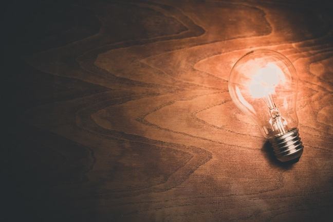 A light bulb on wooden background.