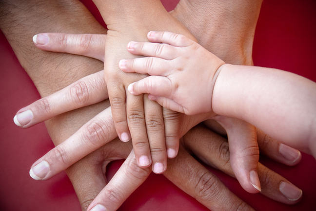 Adult and child hands touching