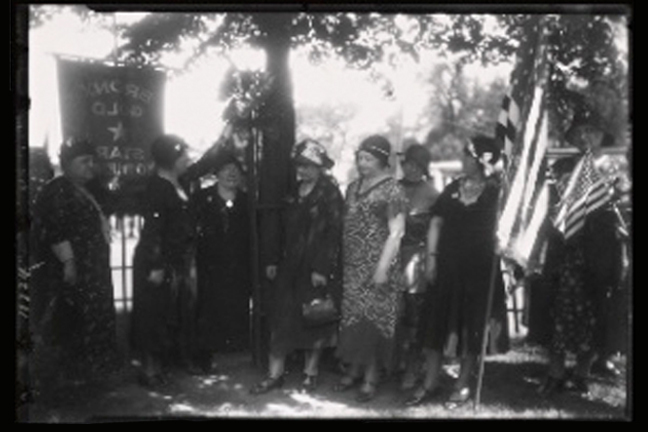 Old photograph showing a group of women with flags and banners