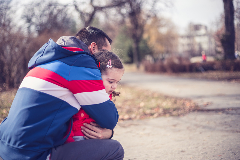 Father hugging his daughter in park