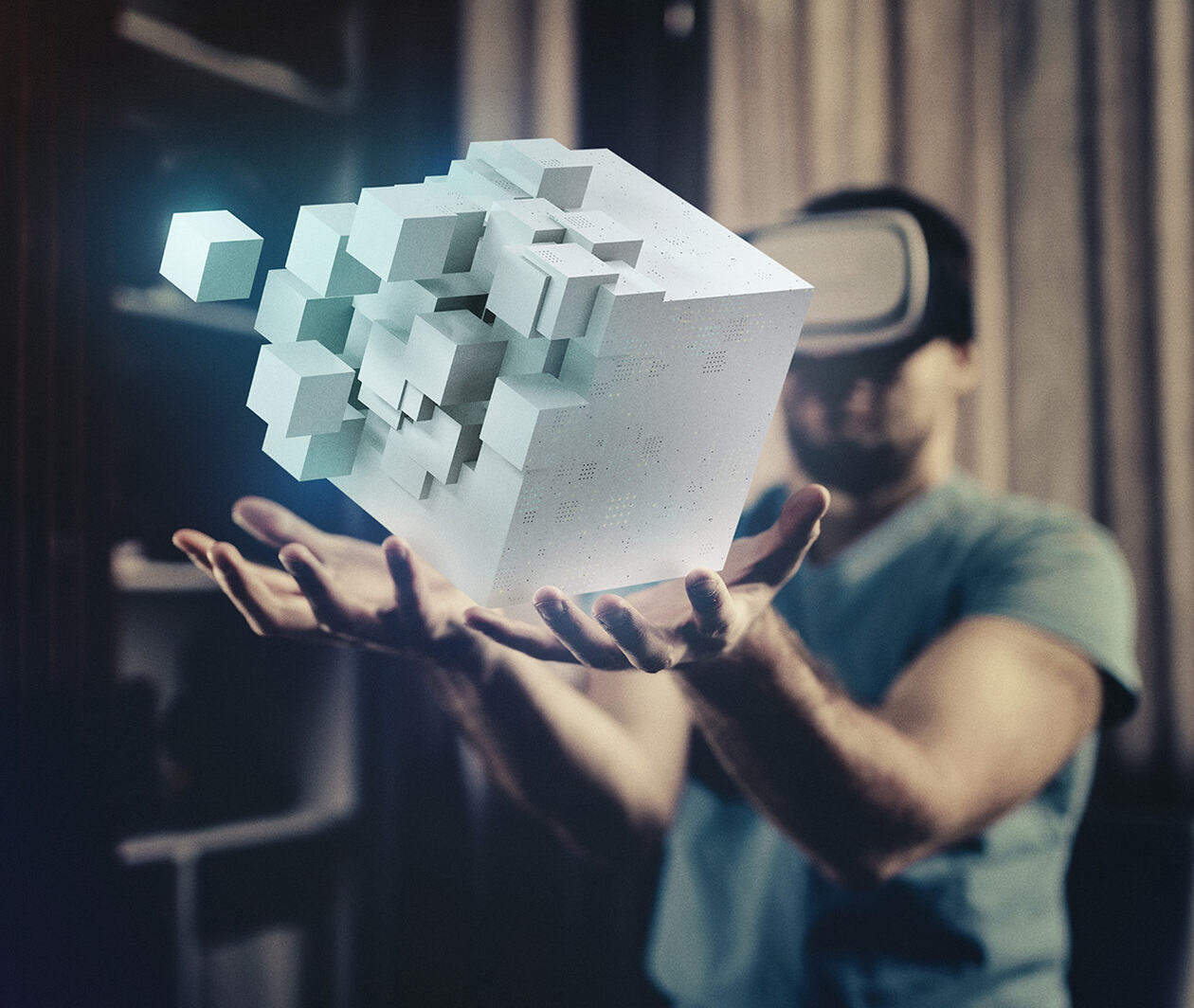 A man wearing a virtual reality headset imagines he is holding a moving block of cubes in the air. 