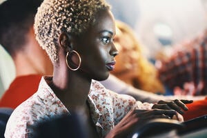 A woman sits on a computer in an office setting.