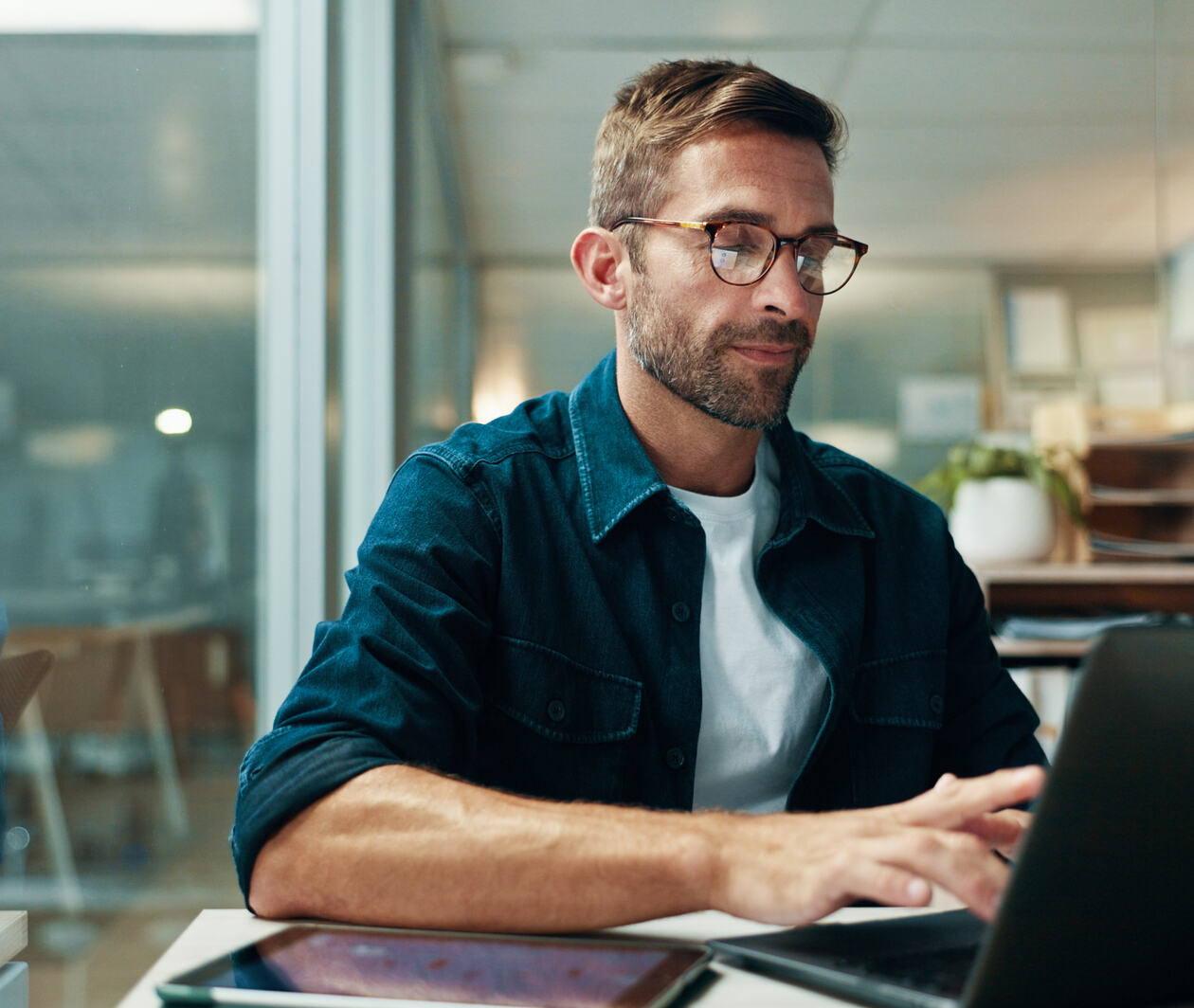 Businessman, typing and laptop in office with night, overtime and writer at publishing agency. Proposal, journalist professional and deadline for news article, reporter and employee in workplace