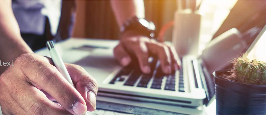 Closeup of hands holding pen and touching keyboard