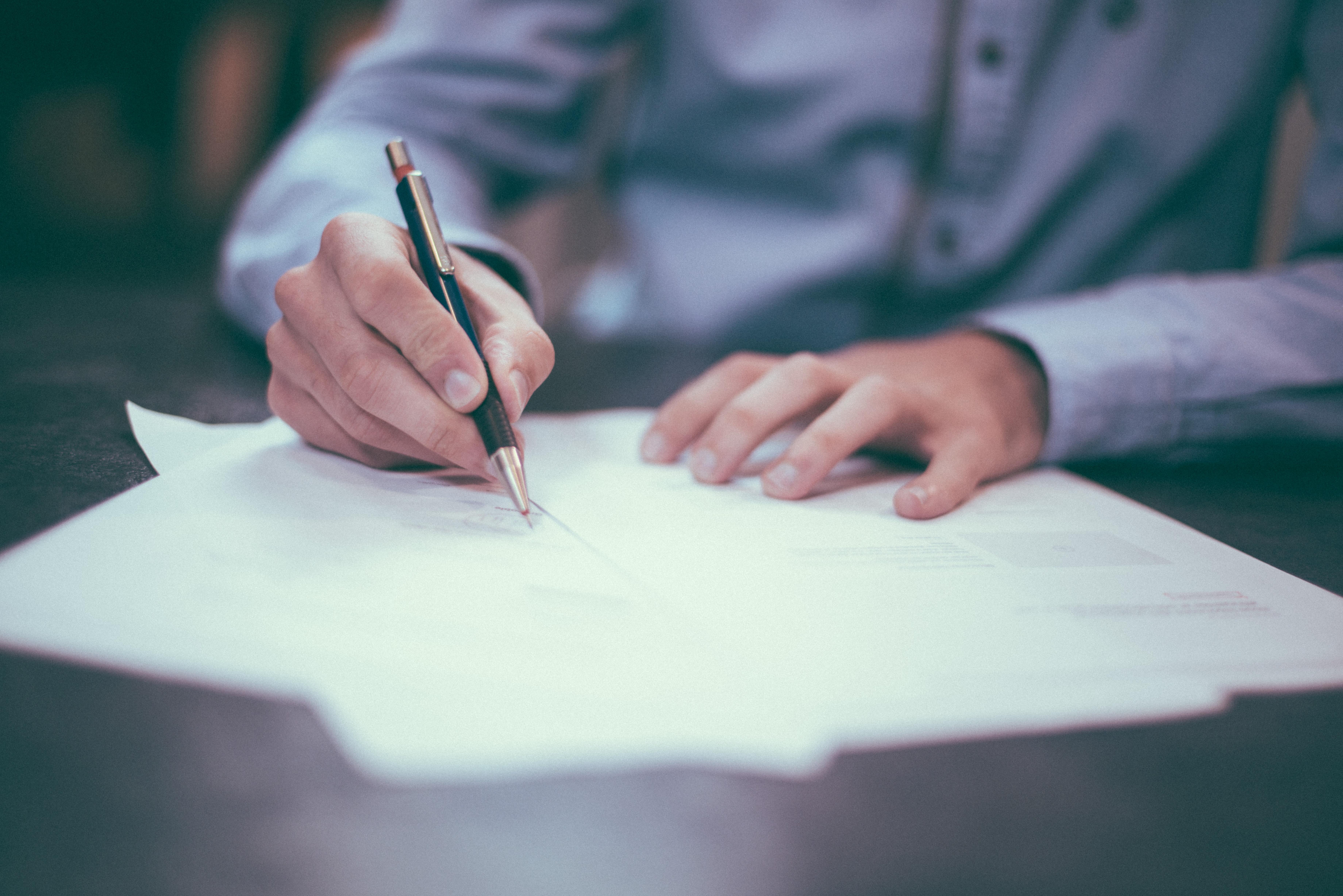 Man writing with a pen on paper