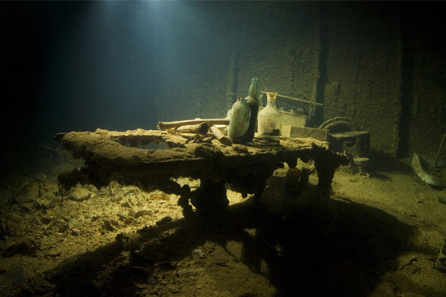 An operating table with bottles and other items on it, underwater.