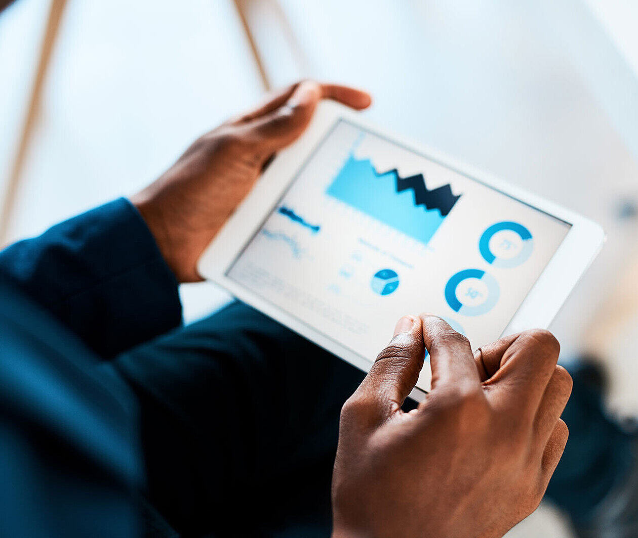 Someone holding a tablet showing some data visualisations