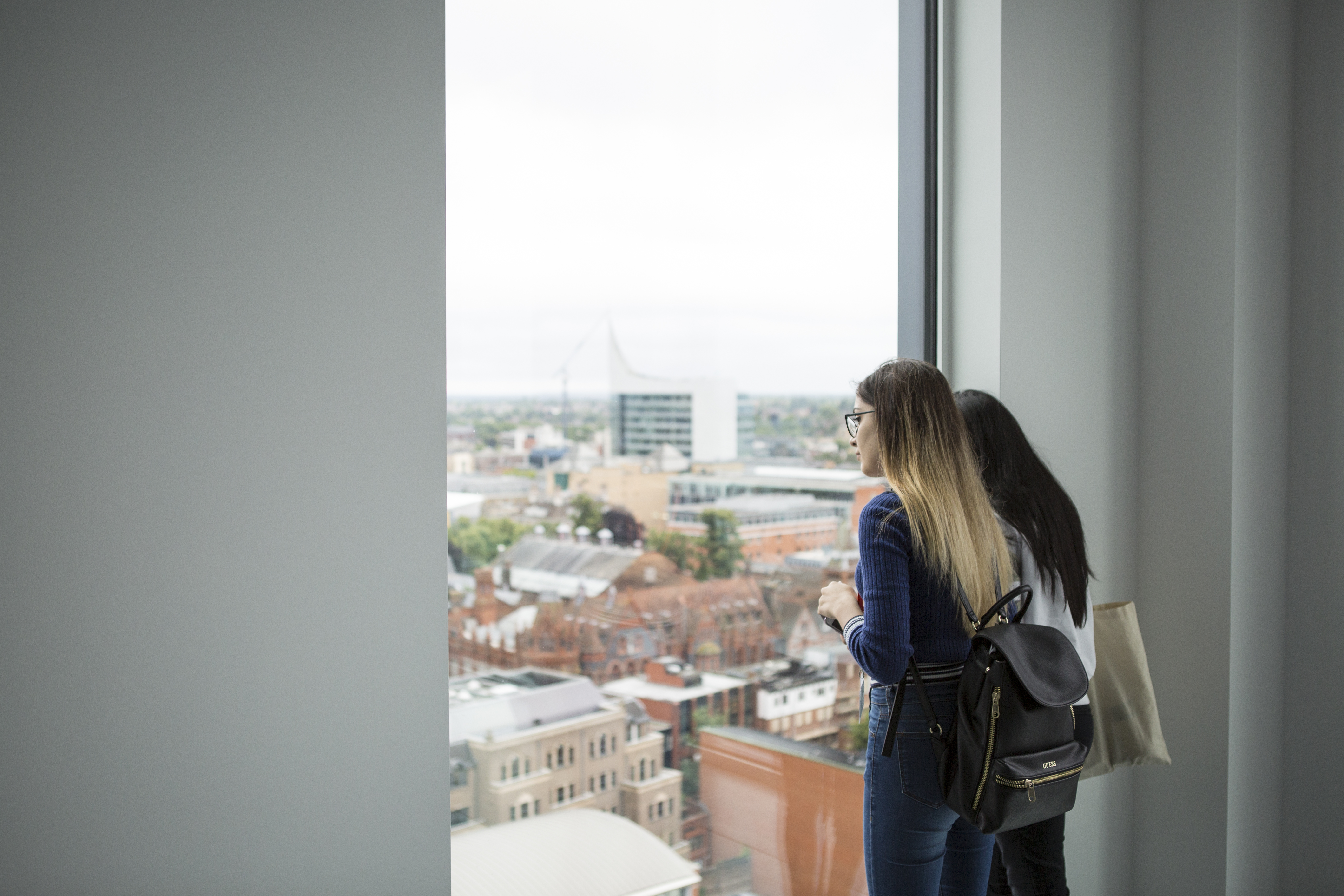 Two students looking out of a window