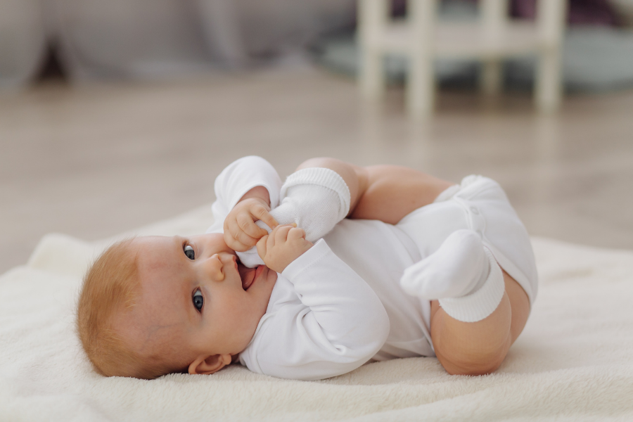 Photo of a small baby lying on their back.