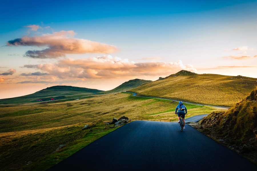 Man riding bike in green valley