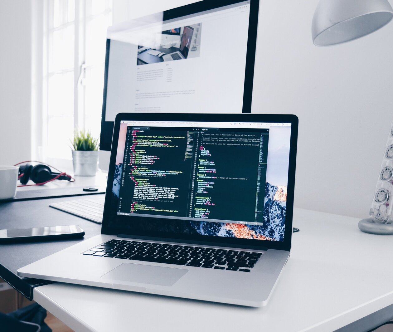 Laptop on a desk with some coding