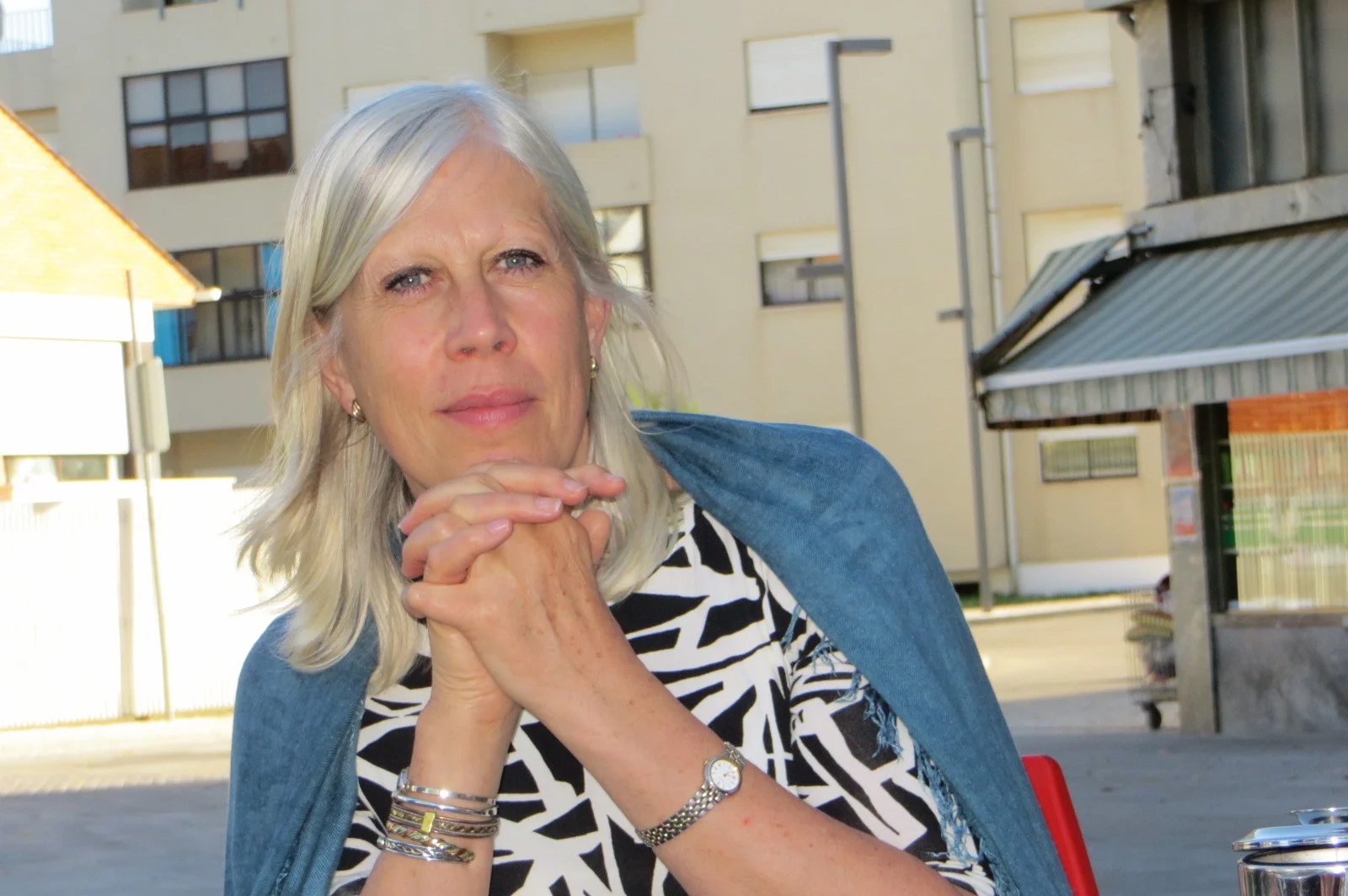 A profile picture of a woman with white hair, wearing a blue cardigan