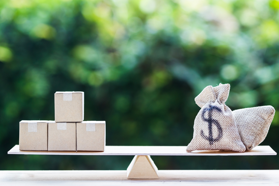 Money and supply concept : Money dollar bag and supply products on balance scale on wooden table depicts balancing between risk and return. Investment between money and supply reverse.