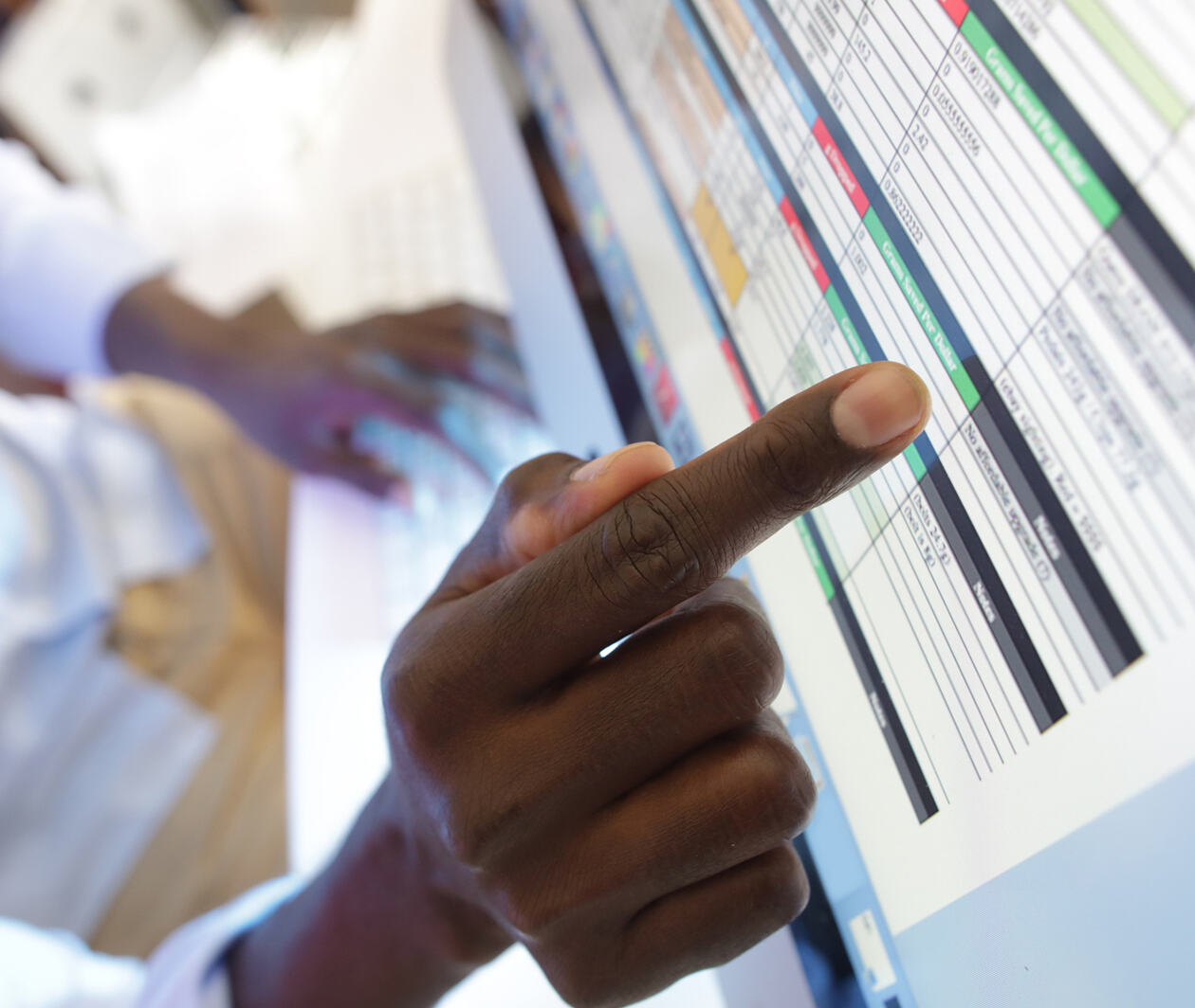 hand pointing to cells on a spreadsheet