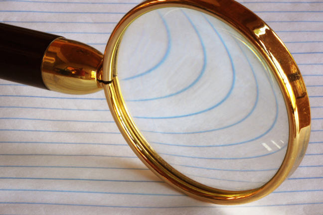 Magnifying glass over a page of blue parallel lines