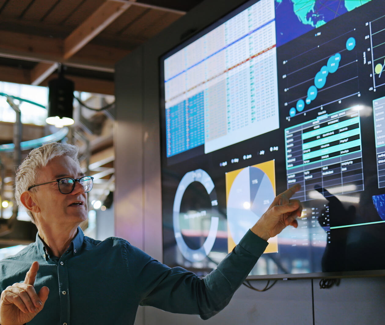 Man pointing at a screen showing data