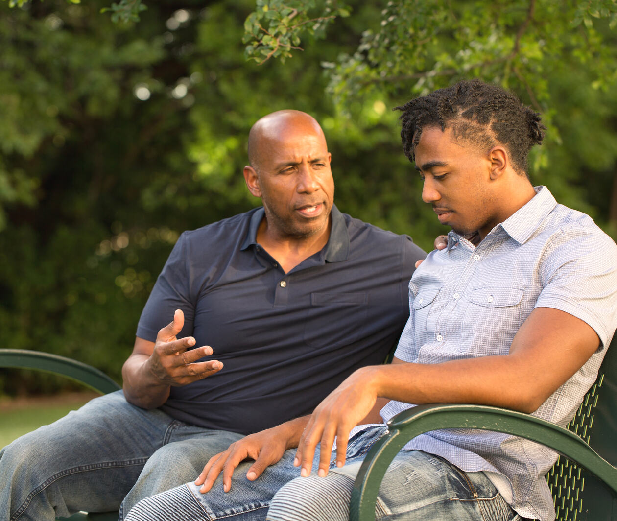 An adult talking to a young person in a supportive way.