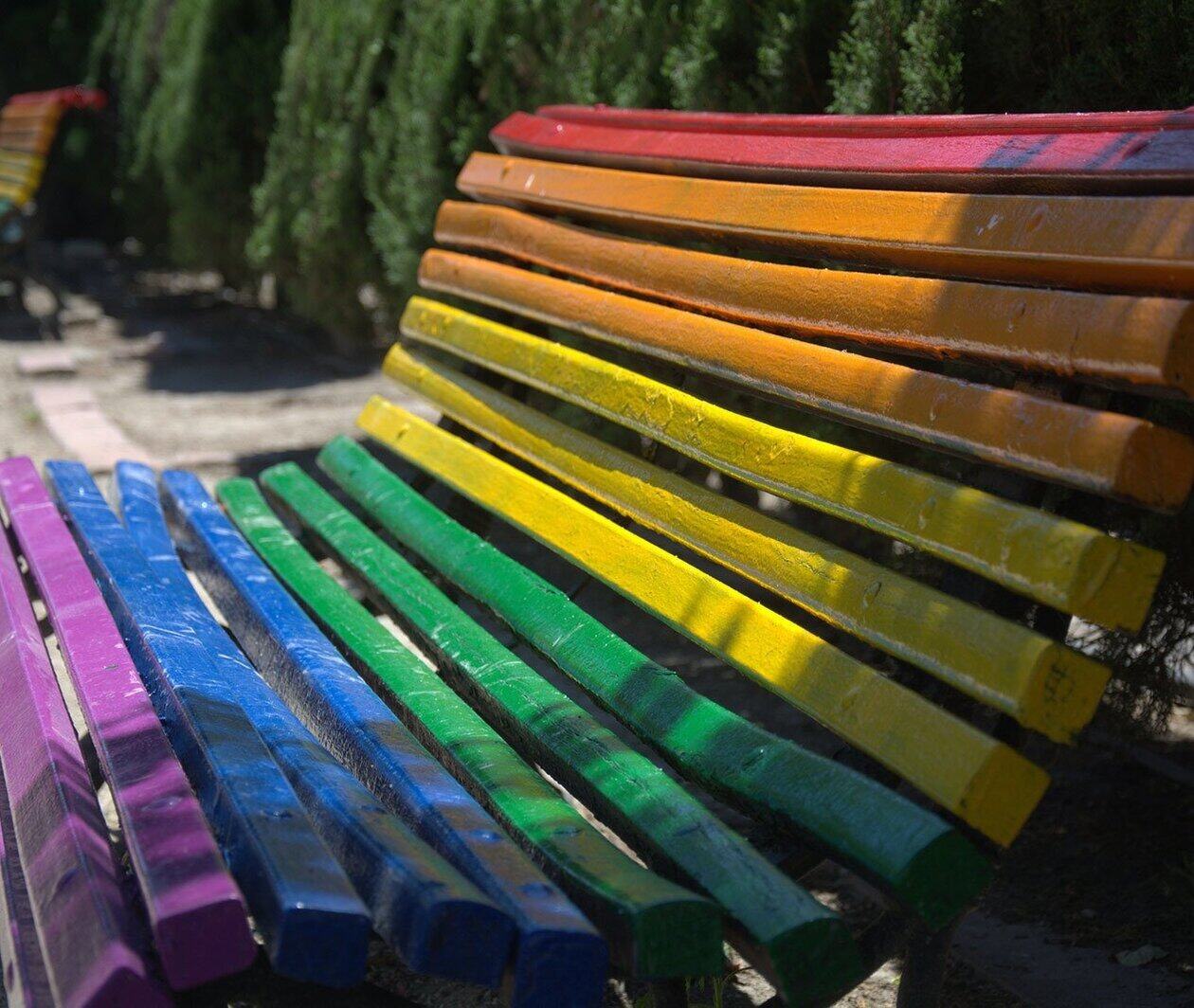 Park bench painted in the colours of the rainbow