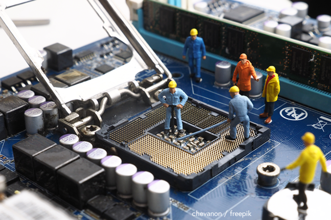 Toy workmen repairing a computer - chevanon / freepik