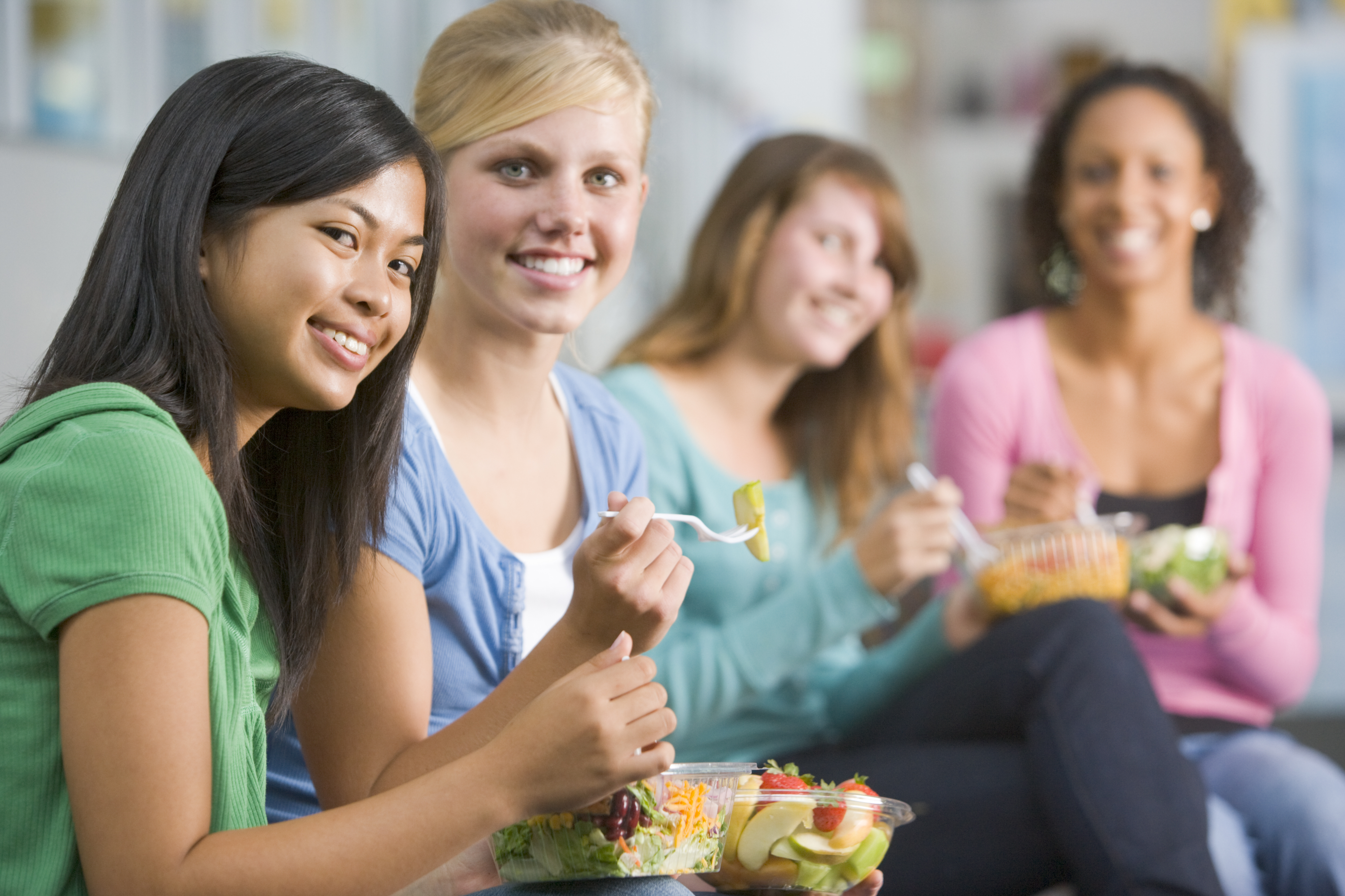 Teenage girls enjoying healthy lunches together