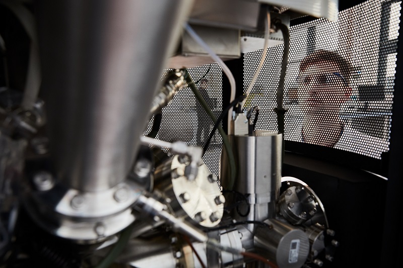 Scientist looking through a grill on a machine