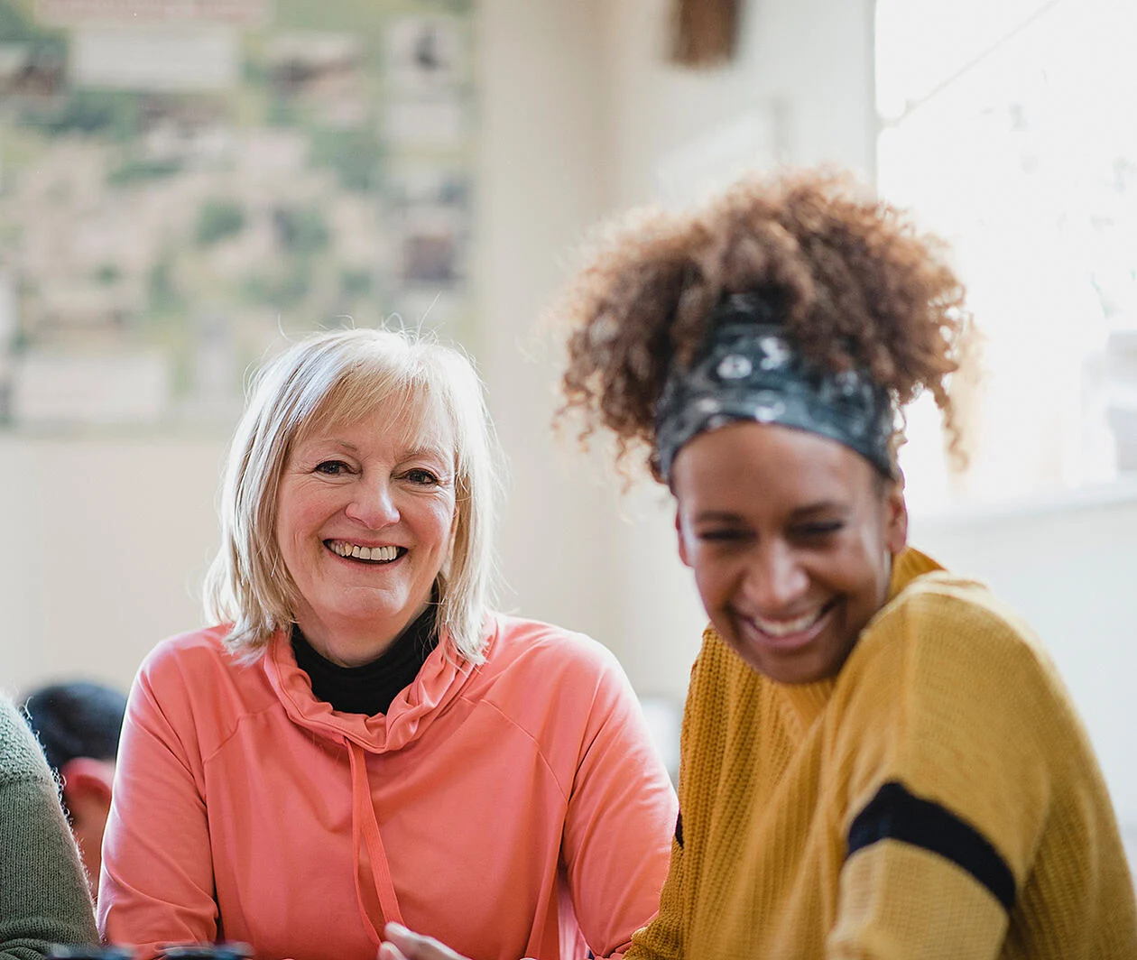 Close-up image of two social care workers, both smiling