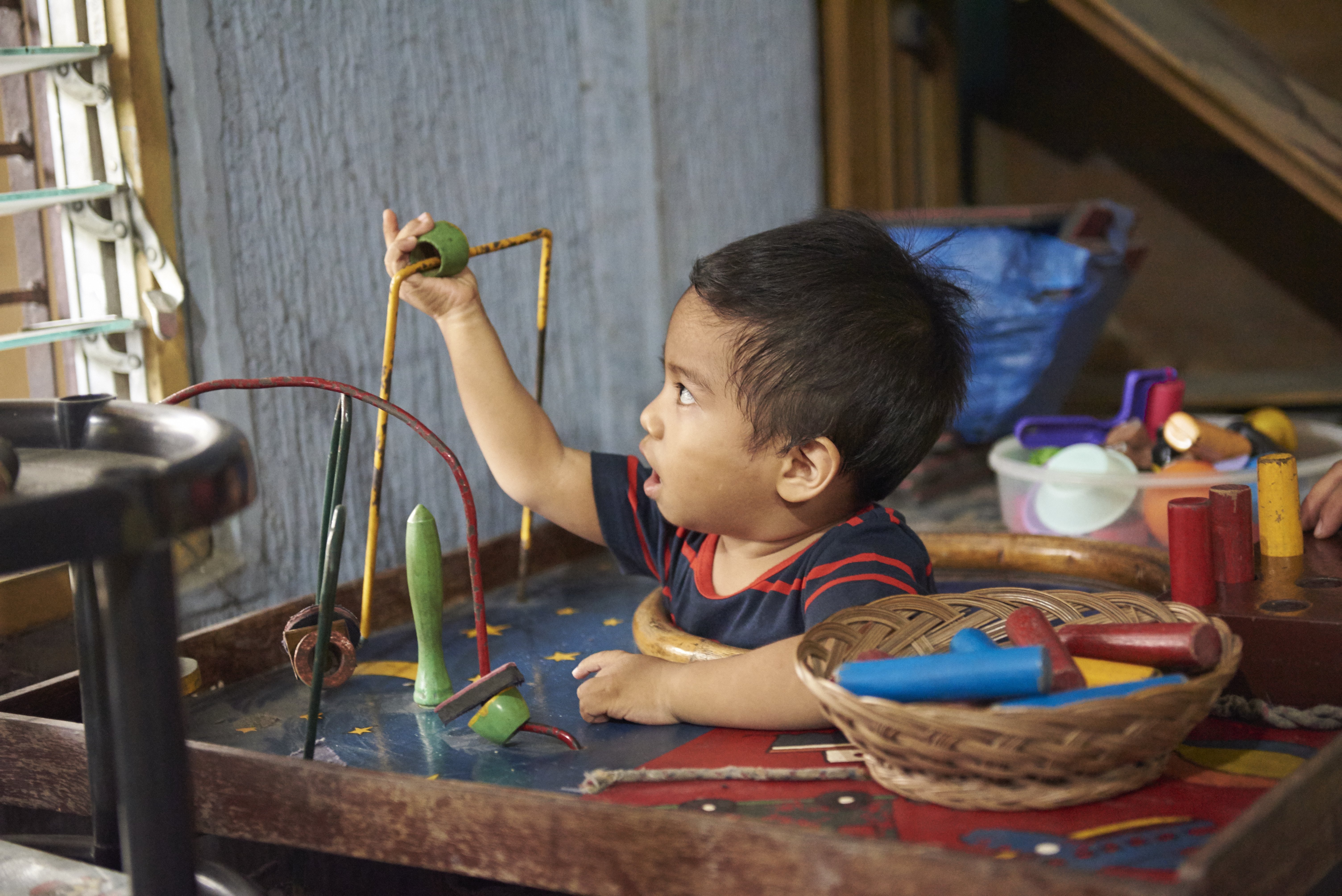 A young boy with cerebral palsy playing with toys.