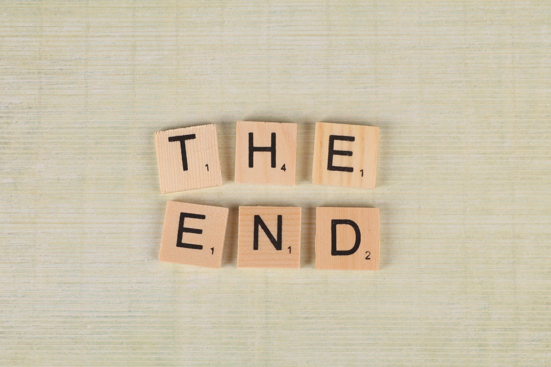 Scrabble tiles arranged on a grey background reading 