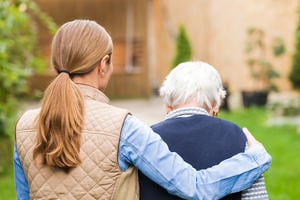 A carer supports an elderly woman with dementia