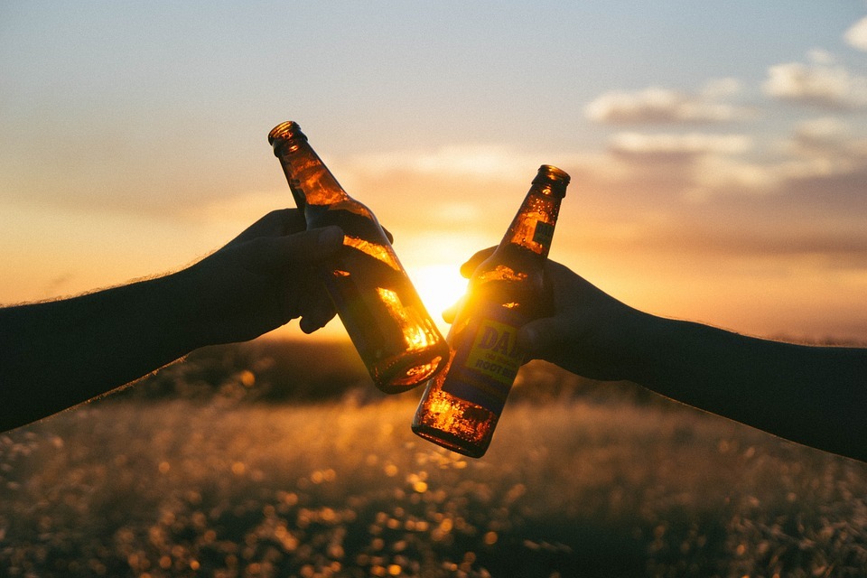 Toasting two bottles of beer.