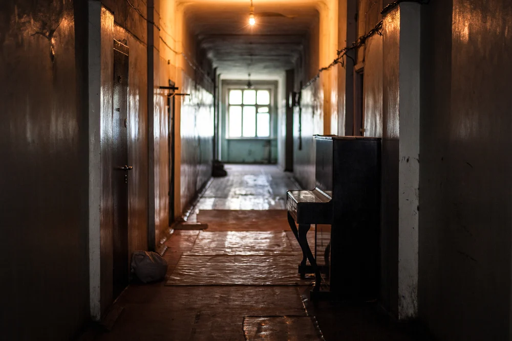 Old piano in a dirty corridor.