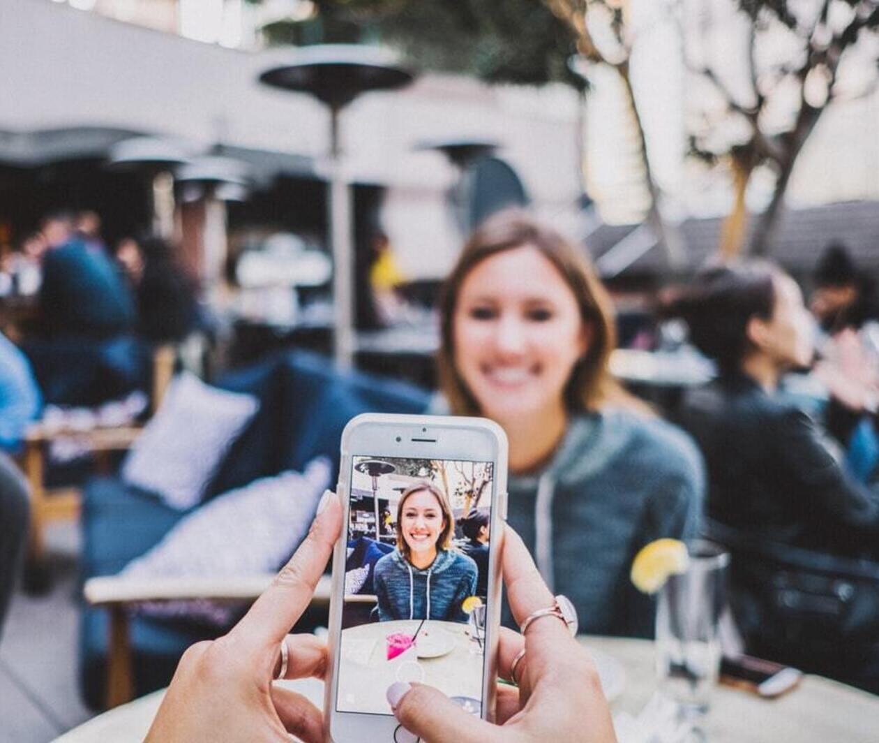 A photo of a woman having a photo taken on a phone