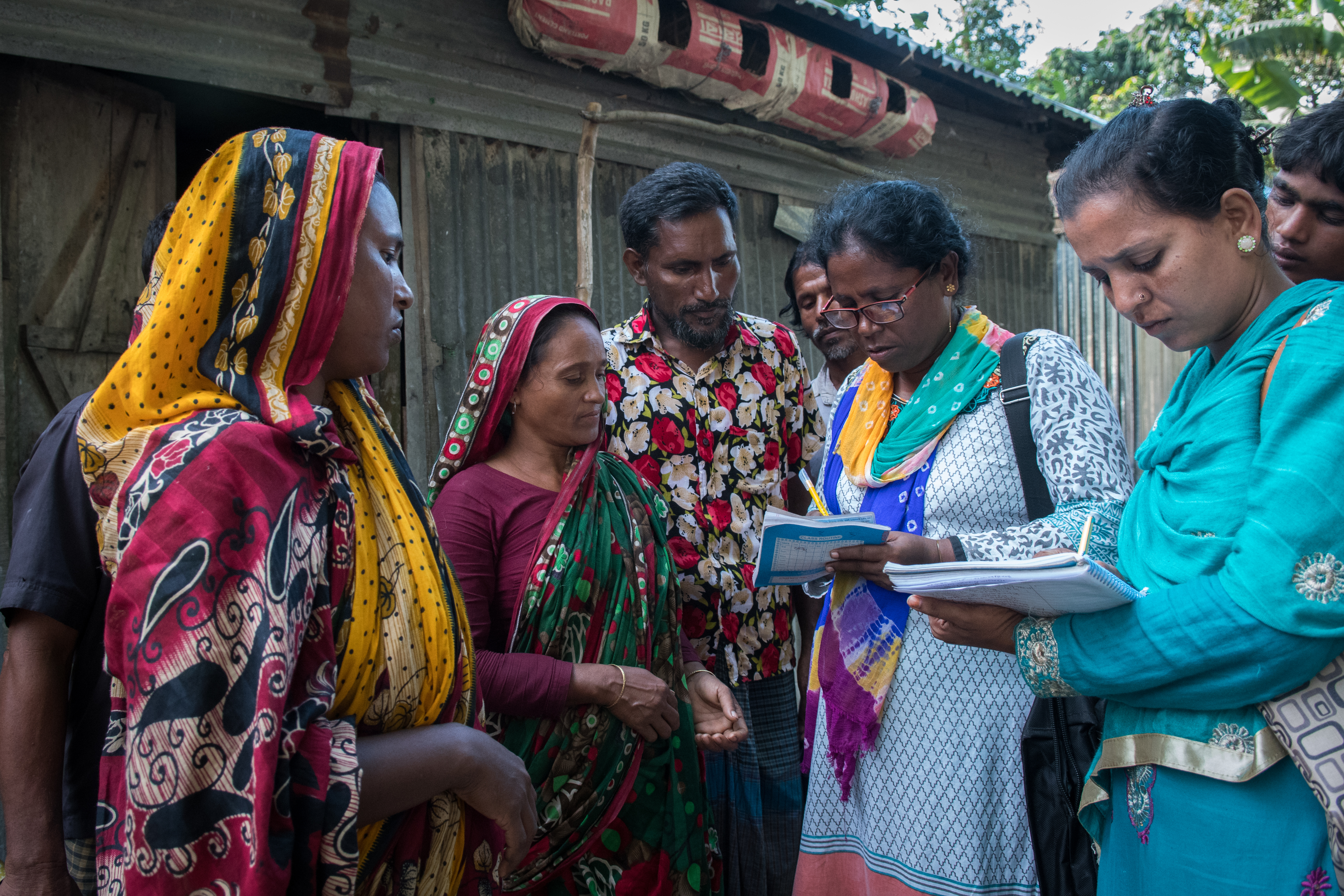 Masura Begum, age 35 of Purba para, Charitabari is receiving referral slip for relief. Mita Alam of CBM local partner GUK is seen signing the slip after making physical visit to masura magums house.