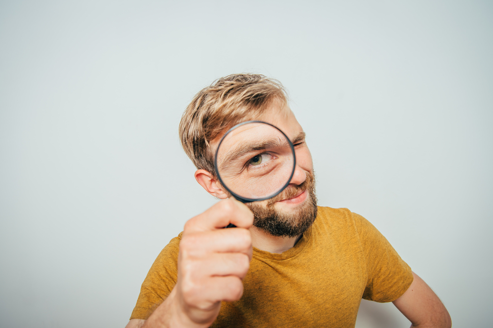 Person looking through a magnifying glass