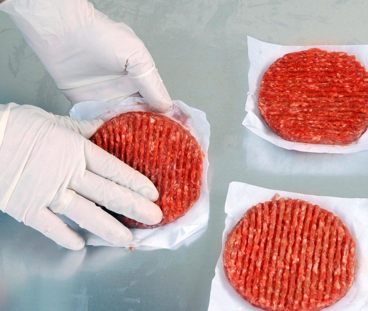 Food scientist handling meat burgers